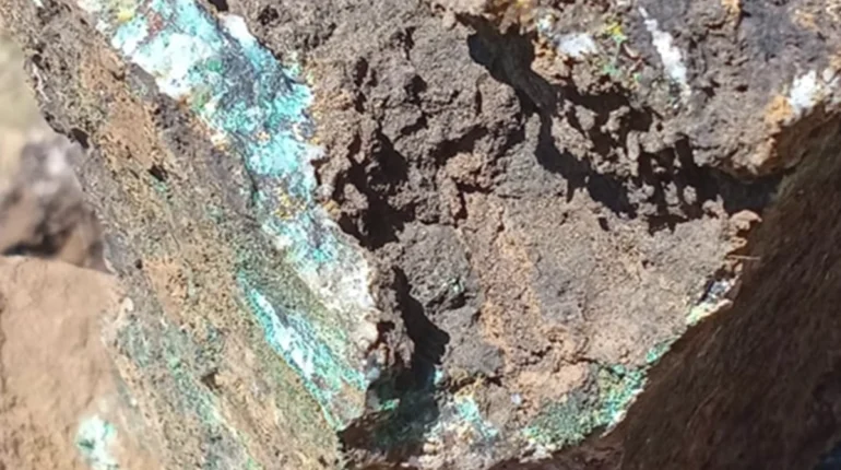 Échantillon de roche prélevé sur le Projet cuivre Ourg montrant une minéralisation visible en malachite et chrysocolle associée à une altération hydrothermale et à un système filonien quartzifère.